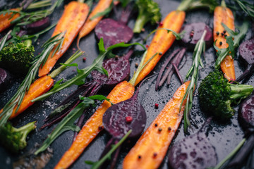 Fresh vegetables for roasting on rustic dark background