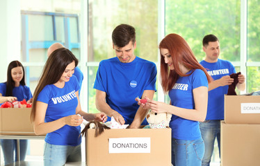 Poster - Young volunteers with box of donations indoors