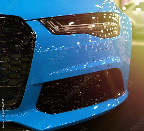 front-view-of-blue-modern-luxury-sport-with-soft-orange-sun-light-car-exterior-details-headlight-of-a-modern-sport-car-the-front-lights-of-the-car