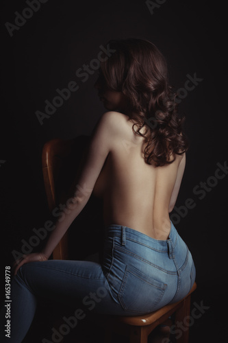 Plakat Opalona kobieta w niebieskie dżinsy z gołym powrotem