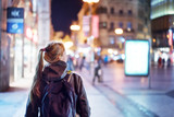 Fototapeta  - Back view of girl walking on city street at night, Prague