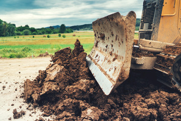 Wall Mural - Yellow mini bulldozer doing landscaping works during house construction site