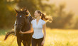 Young woman running with her horse in evening sunset light