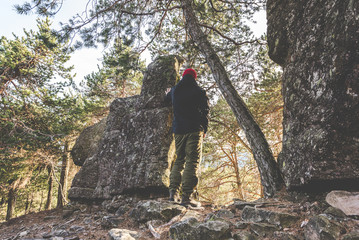 hiker standing on the rocks and contemplates a beautiful mountain landscape -wanderlust travel concept with sporty people at excursion in wild nature - outdoor activity italian Alps Italy