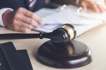 Close up of gavel, Male lawyer working with scales of justice, books, report the case on wooden table in office, Law and justice concept