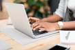© LIGHTFIELD STUDIOS - cropped view of african american businesswoman typing on laptop in cafe