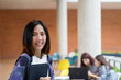 © ChayTee - Portrait of confident cute asian college student in campus university.Cute asian woman holding books and looking at camera, learning and education concept.