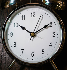 Classical alarm clock ringing on wooden background