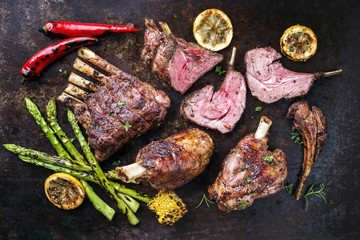 Barbecue Leg of Lamb and Veal Loin with Vegetable as top view on old metal sheet