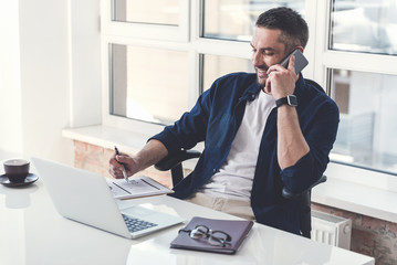 Wall Mural - Stylish adult manager is having pleasant communication on smartphone