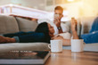 © Jacob Lund - Coffee cups on table with couple relaxing in background
