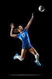 Female professional volleyball player isolated on black