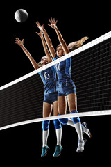 Wall Mural - Female professional volleyball players isolated on black