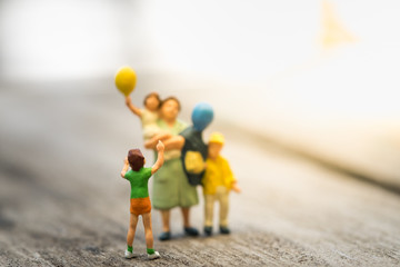 Family and kid concept. Child and mother miniature figure playing balloon with family.