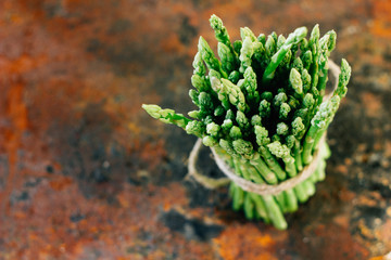 Hip of fresh asparagus on metal rustic board.