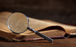 © Rawf8 - Vintage book and magnifying glass on wooden desk
