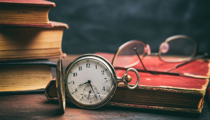 Canvas Print - Vintage books and pocket watch on dark background