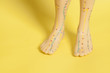 Medical acupuncture model of human feet on yellow background