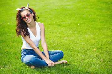 Happy young woman sitting on fresh juicy grass