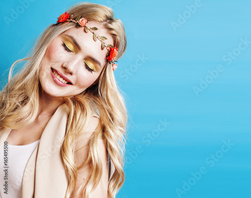 mloda-piekna-dziewczyna-z-blond-wlosami-i-wiankiem-na-glowie-na-turkusowym-tle