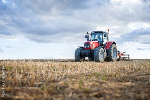 Fotografia agricultural machinery in the foreground carrying out work in the field