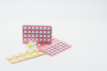 Wall Mural - Birth control pills with flower in white background