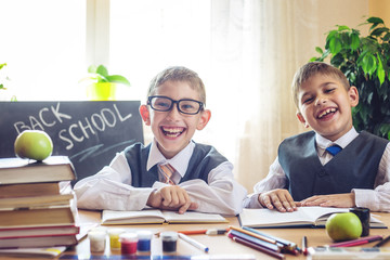 Back to school. Cute children sitting at the desk in the classroom. Boys is learning lessons. Concept elementary school