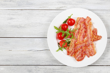 Wall Mural - fried bacon, tomatoes, arugula on plate