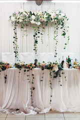 Wall Mural - Green branches hang from the bouquets on the table