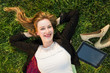 young independent woman relaxing on grass in park