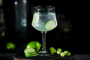 Wall Mural - Green lime lemonade cocktail ice tonic on dark background