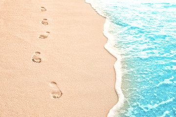 Sticker - Human footprints on beach sand at resort in evening