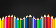 Wave Of Colorful Wooden Pencils Isolated On A Black Board Background, Back To School Concept