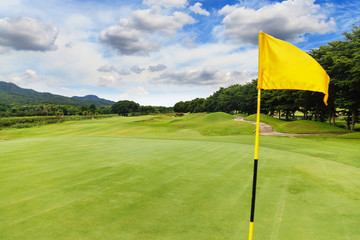 Wall Mural - Yellow flag at the beautiful golf course with blue sky