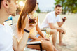 © nazarovsergey - Young people enjoying summer vacation sunbathing drinking at beach bar