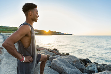 Wall Mural - Young african sportsman warming up before jogging