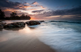 Fototapeta Krajobraz - Seascape sunset with long expose effect with waves trails. Image contain soft focus due to long exposure.