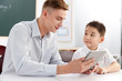 © View Stock - Male teacher helping student study