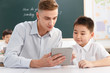 © View Stock - Male teacher helping student study