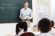 © View Stock - Male teacher teaching students in classroom