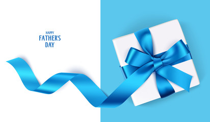 decorative gift box with blue bow and long ribbon. happy father's day text. top view