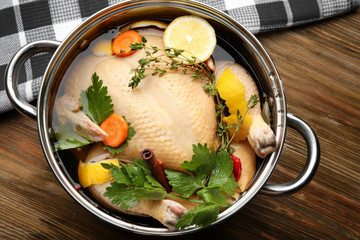 Wall Mural - Cooking pot with turkey soaked in flavored brine on wooden table