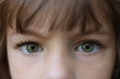 Close up of a young brown haired girl with piercing green eyes
