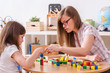 © lordn - Preschool Teacher and Kid Playing with Wooden Building Blocks