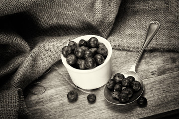 Wall Mural - Pot of blueberries with spoon on a rustic background