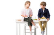 © LIGHTFIELD STUDIOS - cute little children studying while sitting on table isolated on white