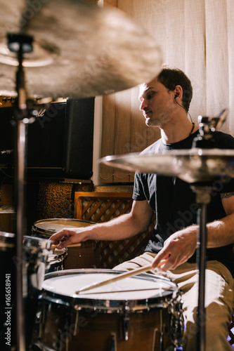 Plakat Mężczyzna perkusista bawić się bębeny w studiu nagrań. Próba przed koncertem muzyki na żywo