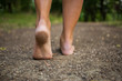 Leinwandbild Motiv Young woman walking barefoot through the forest