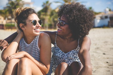 Two best female friends on beach looking at each other