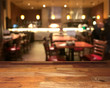 Empty wooden table top with blurred restaurant on background